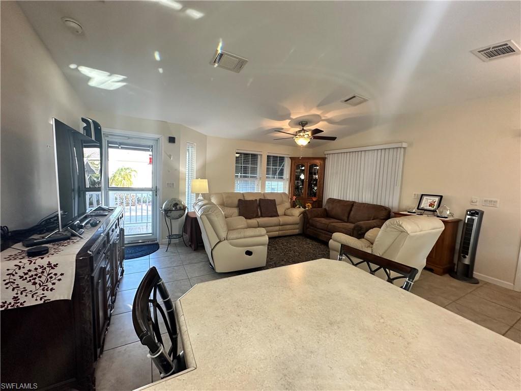 Living room with light tile patterned floors and a ceiling fan