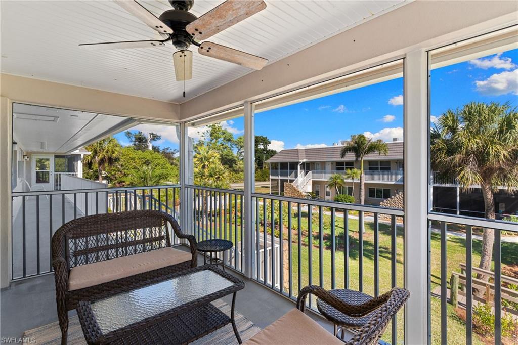 Sunroom featuring a balcony and a ceiling fan