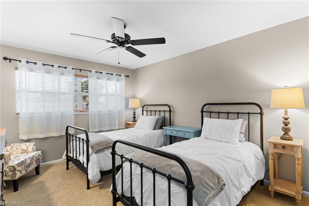 Carpeted bedroom with ceiling fan and baseboards