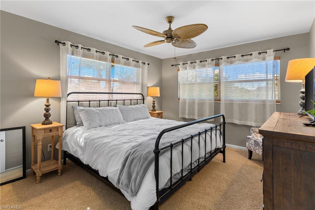 Carpeted bedroom featuring a ceiling fan and baseboards
