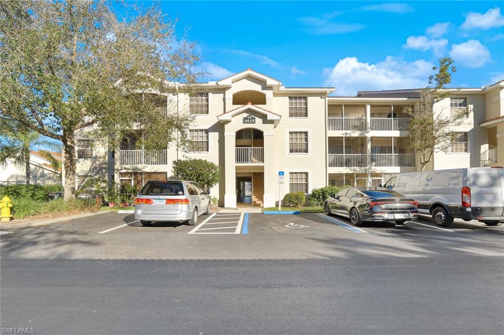 View of apartment building / complex featuring uncovered parking