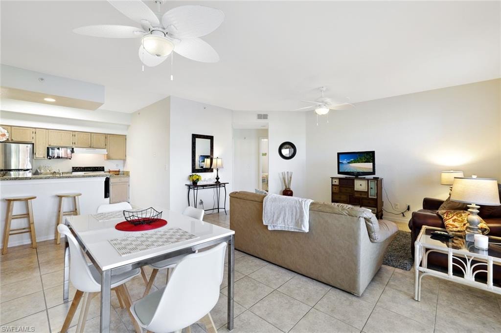 Dining area with light tile patterned floors, ceiling fan, and recessed lighting