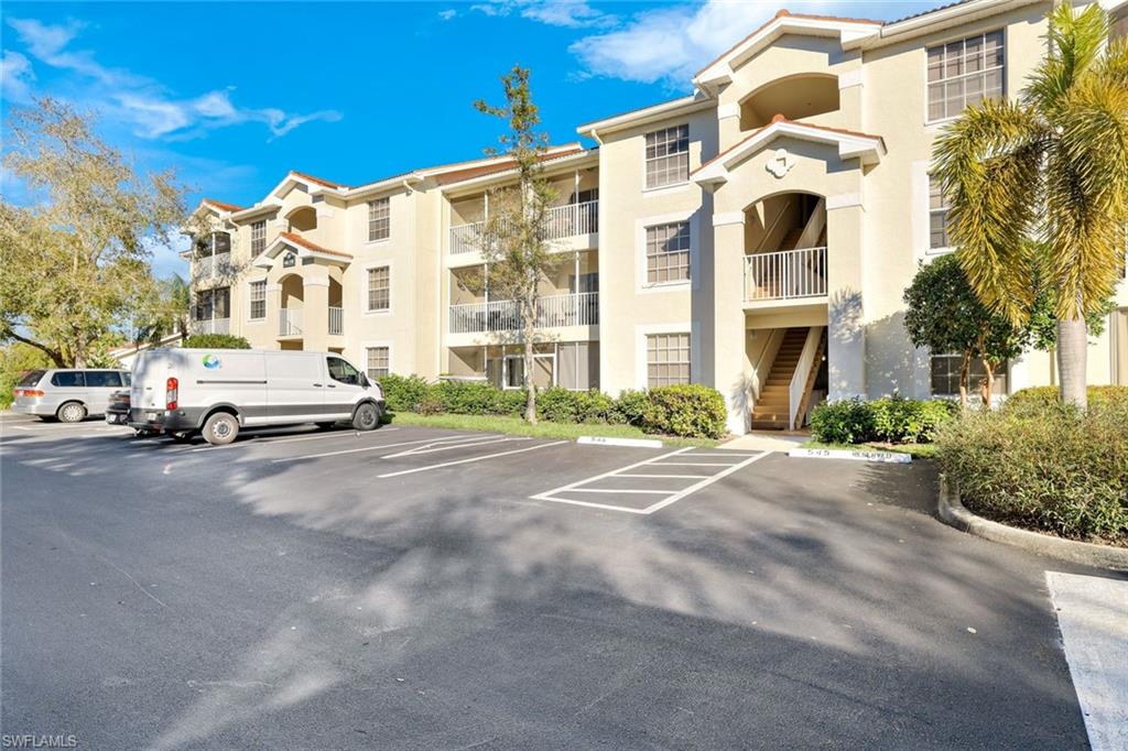 View of apartment building / complex with uncovered parking