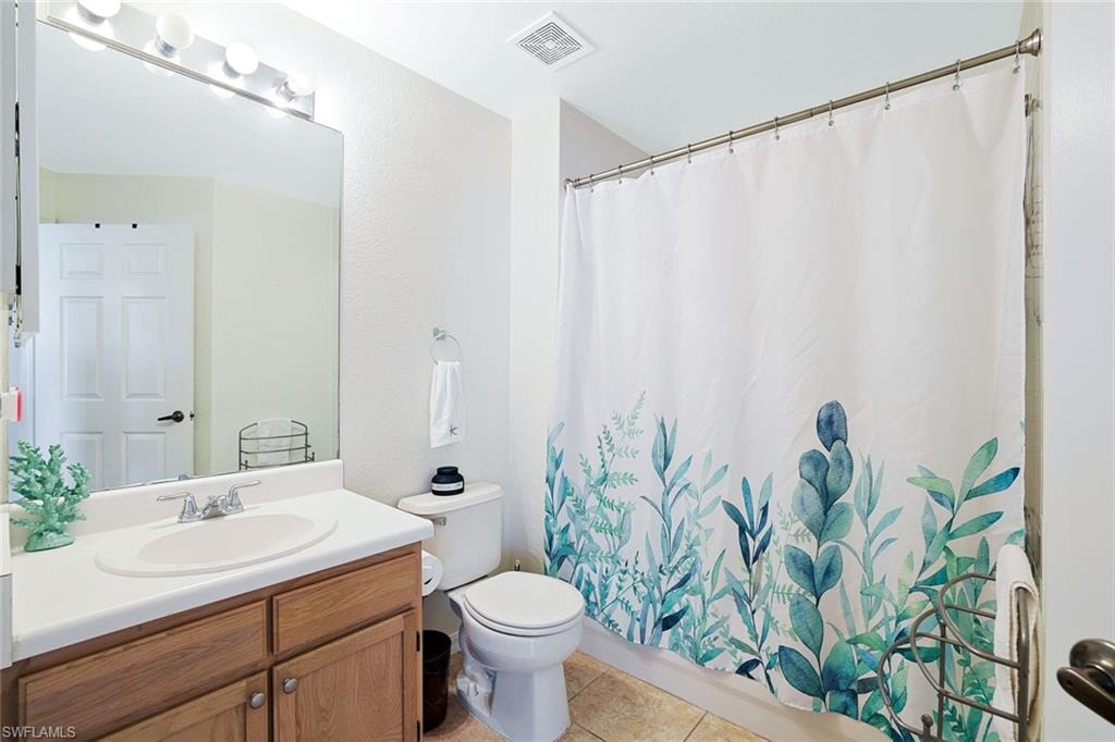 Full bath with vanity, light tile patterned flooring, and shower / tub combo with curtain