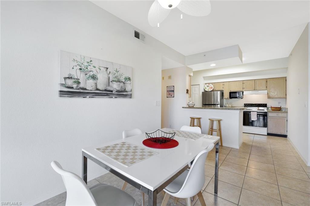 Dining area featuring light tile patterned floors and ceiling fan