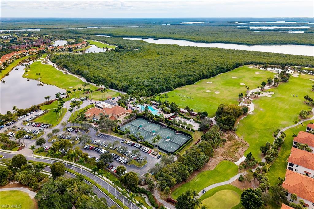 Aerial view of property and surrounding area with a local golf course and a nearby body of water
