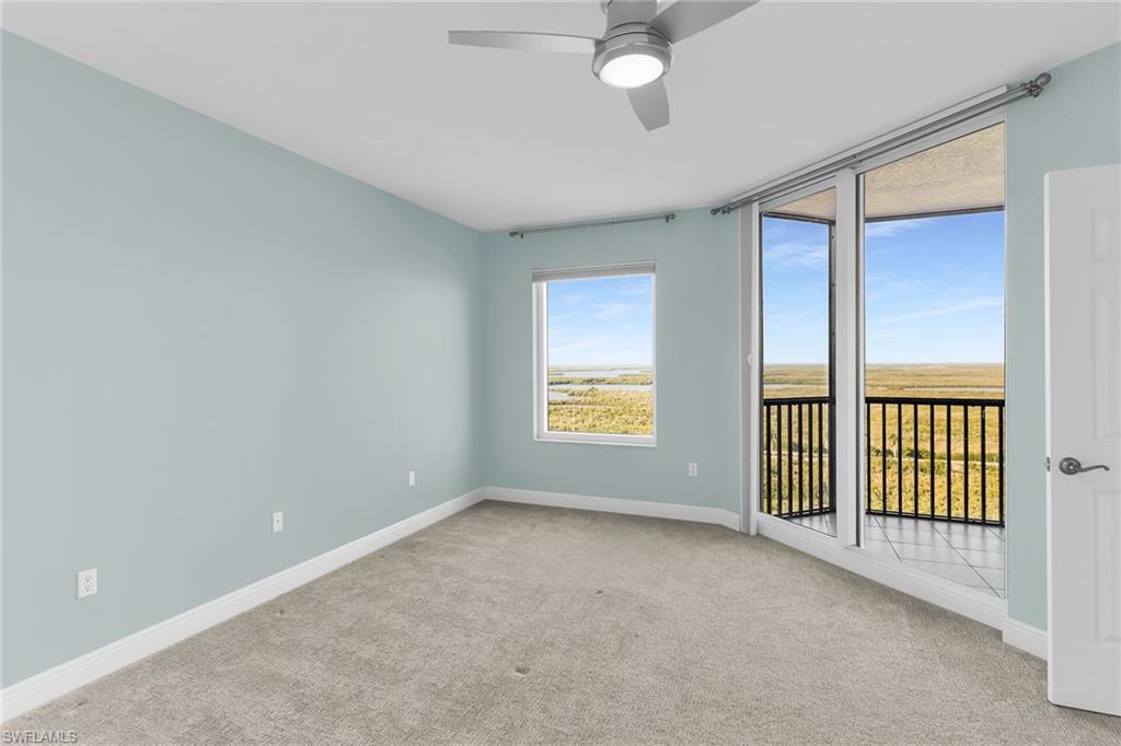 Carpeted spare room featuring a ceiling fan and baseboards