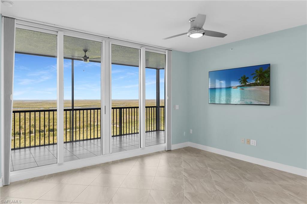 Unfurnished room featuring a wall of windows and a ceiling fan