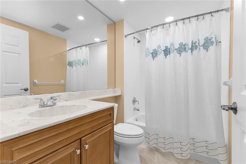 Bathroom with shower / bath combo, vanity, and recessed lighting