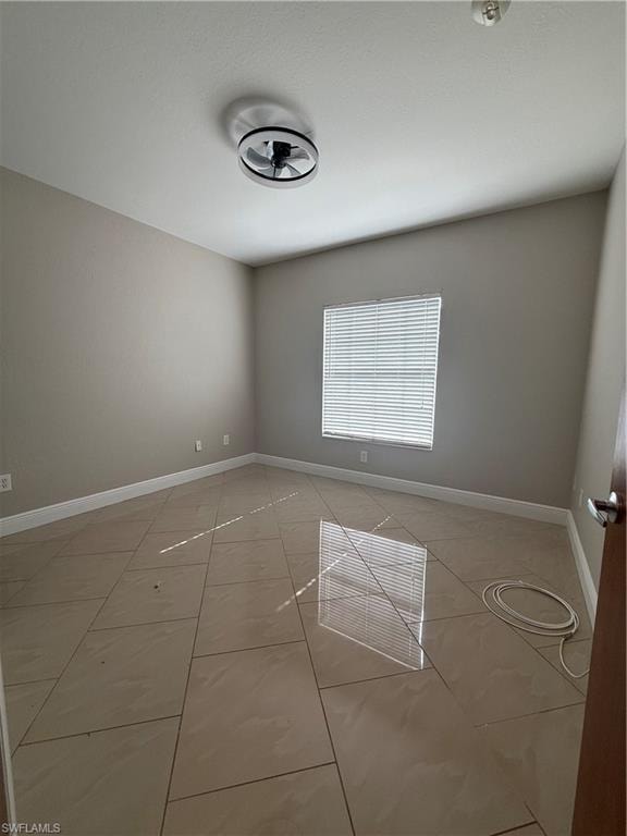 Unfurnished room with baseboards and light tile patterned floors