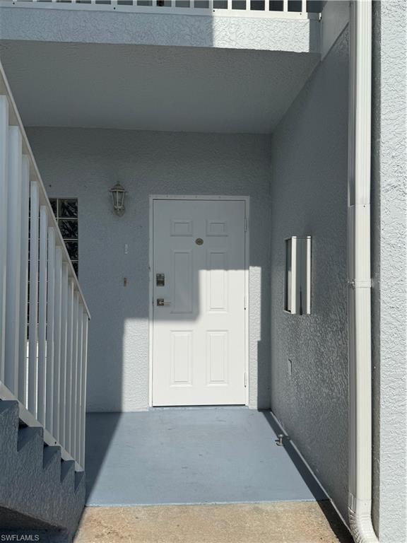 Property entrance featuring stucco siding and a patio