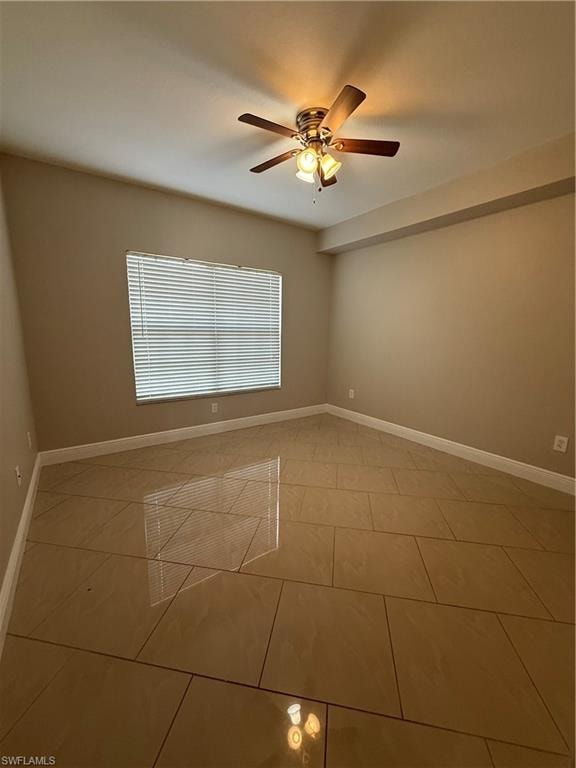Spare room featuring ceiling fan and tile patterned flooring
