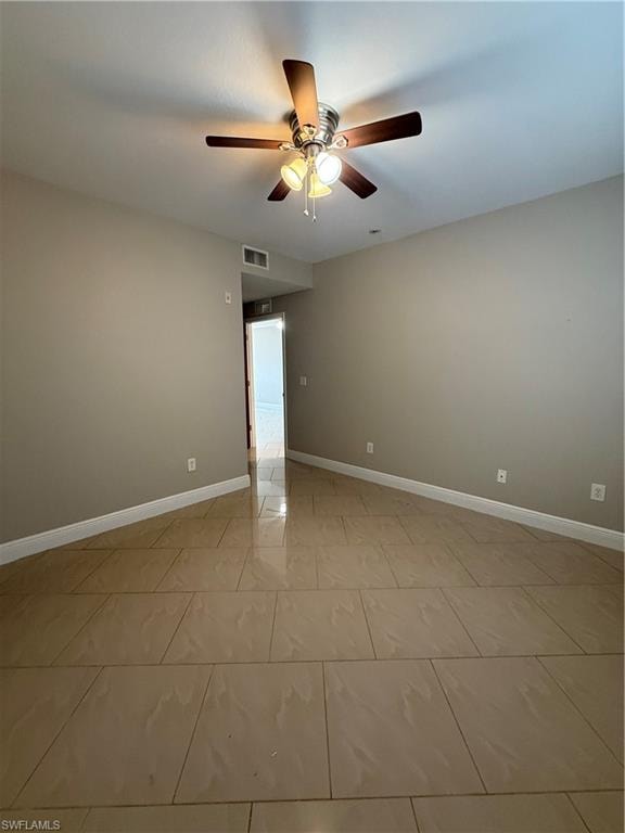 Spare room with ceiling fan and light tile patterned flooring