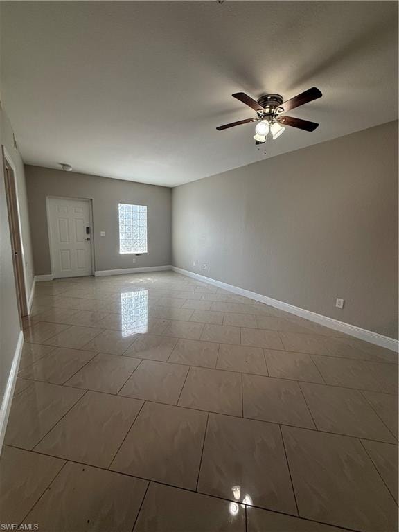 Spare room featuring light tile patterned flooring and a ceiling fan