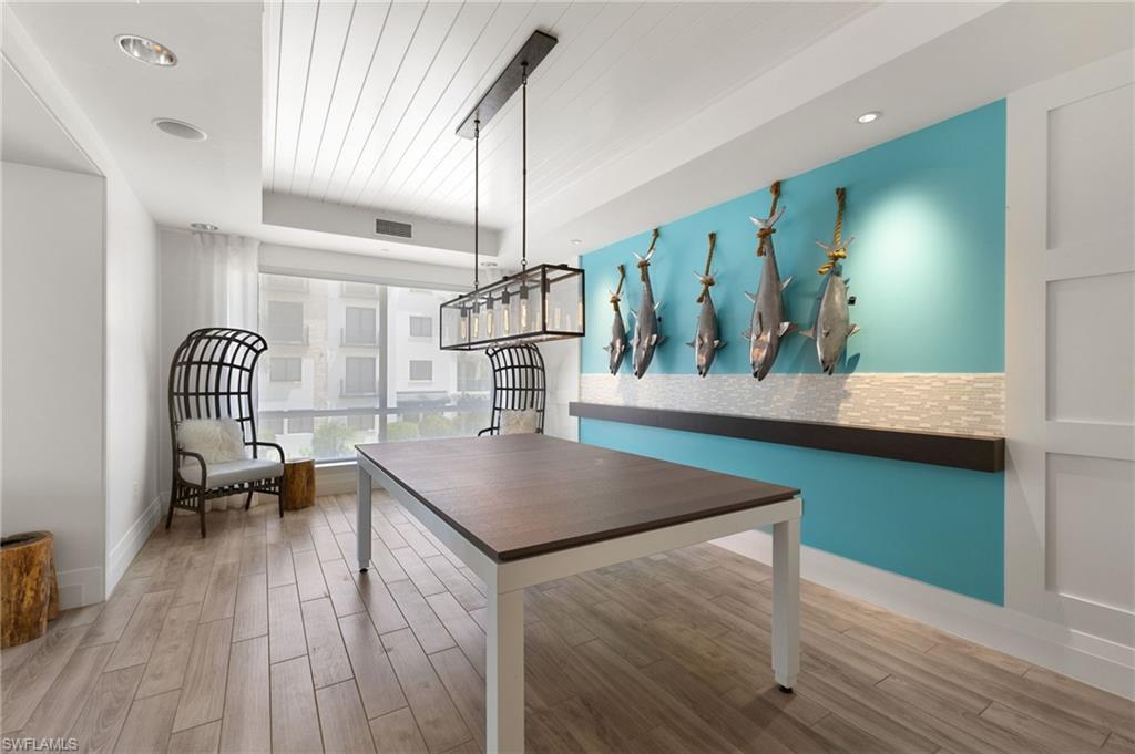 Dining room with light wood-style flooring and a raised ceiling