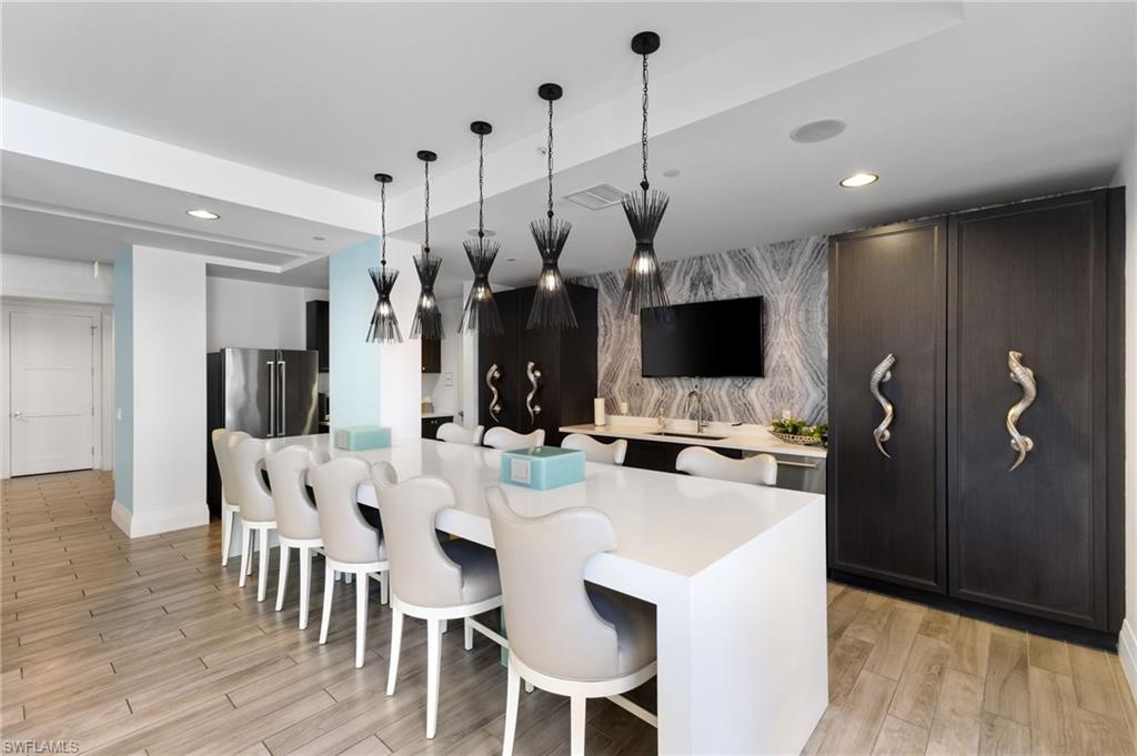 Kitchen featuring an accent wall, hanging light fixtures, recessed lighting, a breakfast bar area, and a spacious island
