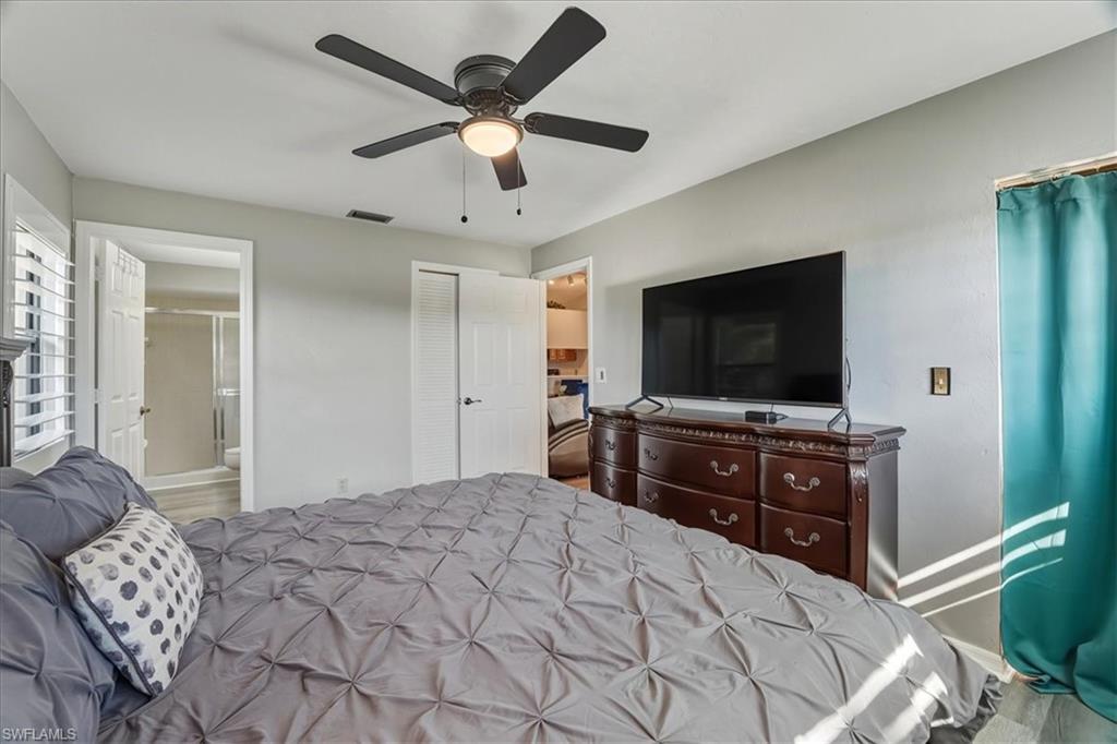 Bedroom with ceiling fan, ensuite bathroom, and a closet
