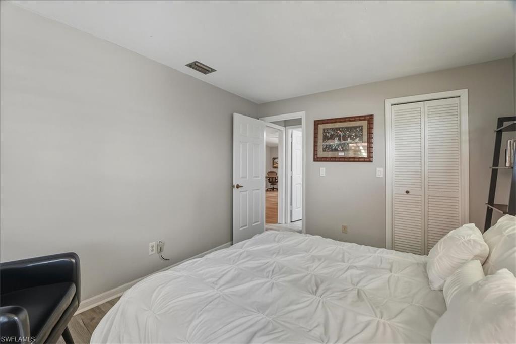 Bedroom with wood finished floors and a closet