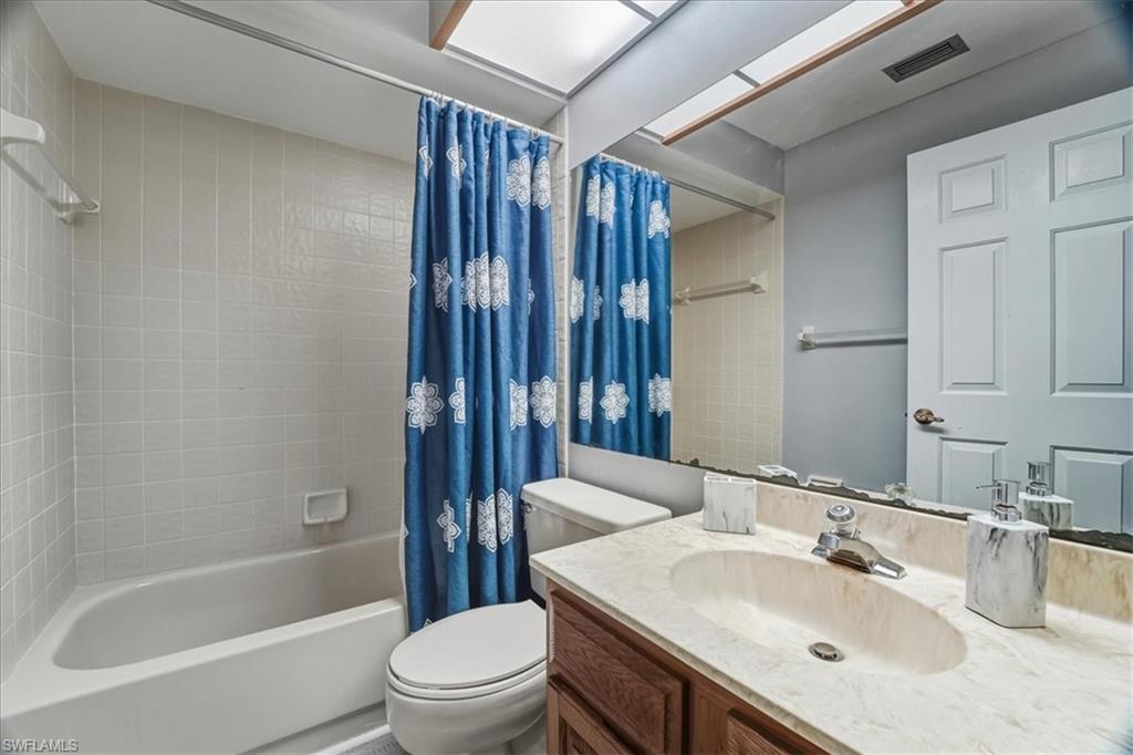Full bath with shower / bath combo with shower curtain and vanity