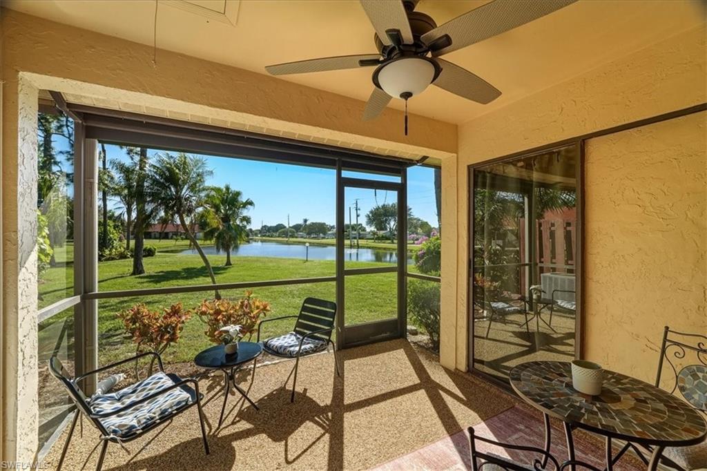 Sunroom with a water view and a ceiling fan