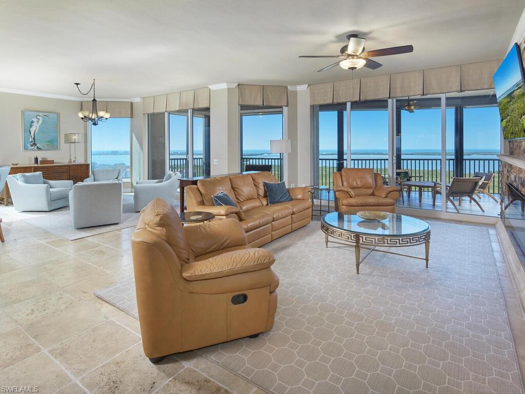 Living area with a chandelier, crown molding, and a ceiling fan