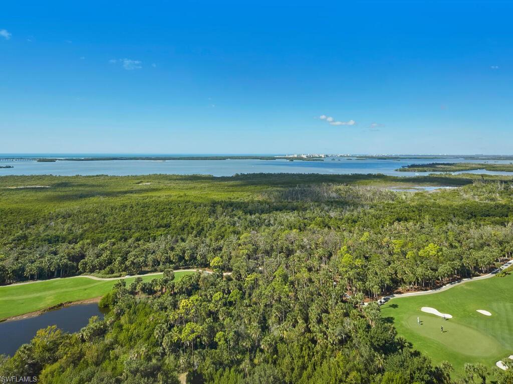 Aerial view of property's location featuring a nearby body of water and a golf course