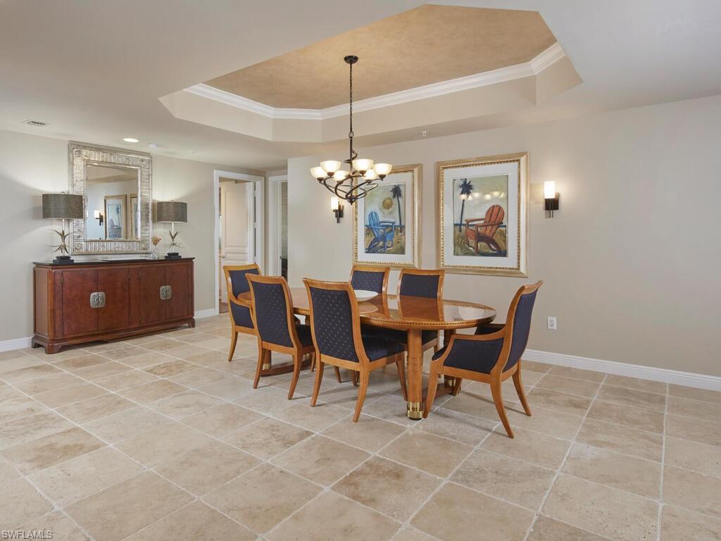 Dining space featuring ornamental molding, light tile patterned floors, and a chandelier
