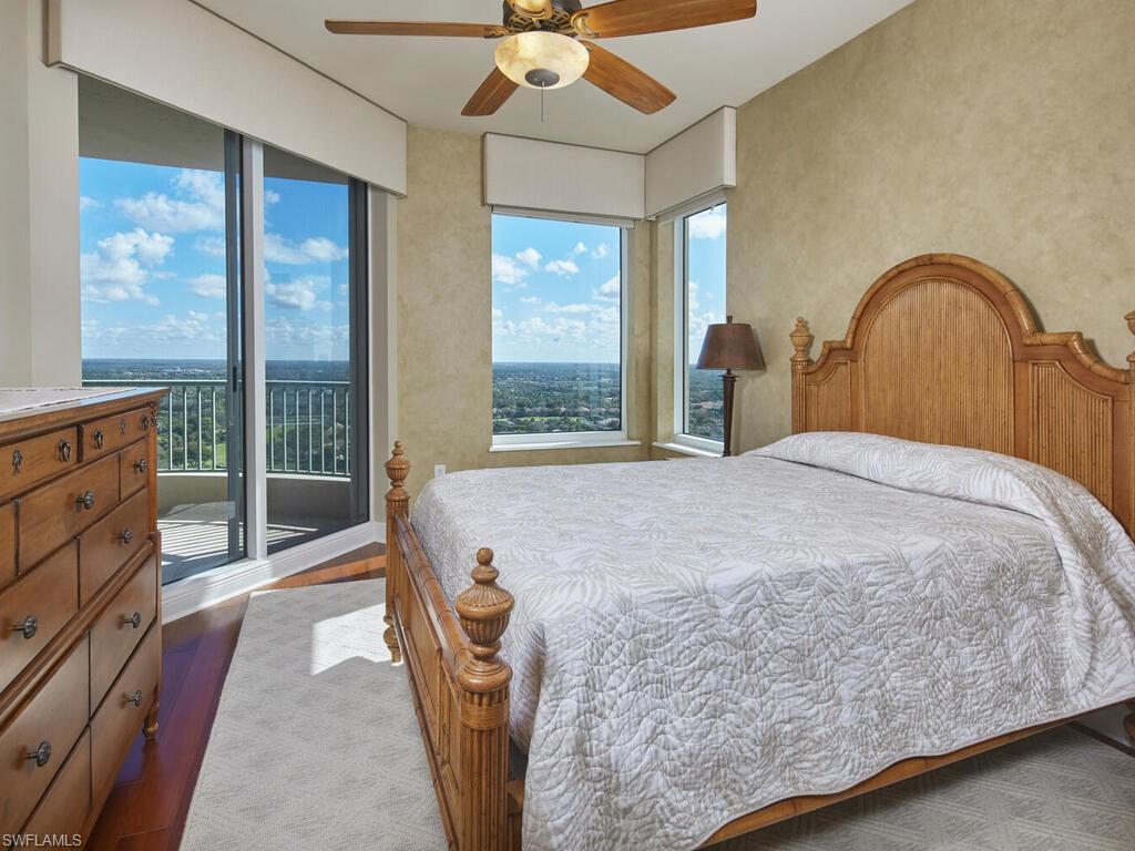 Bedroom with ceiling fan, access to exterior, and dark wood-style flooring