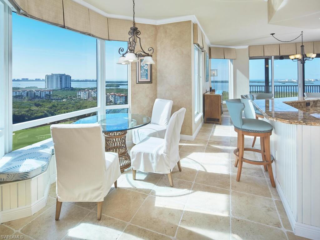 Dining space with a chandelier, a water view, light tile patterned flooring, and ornamental molding