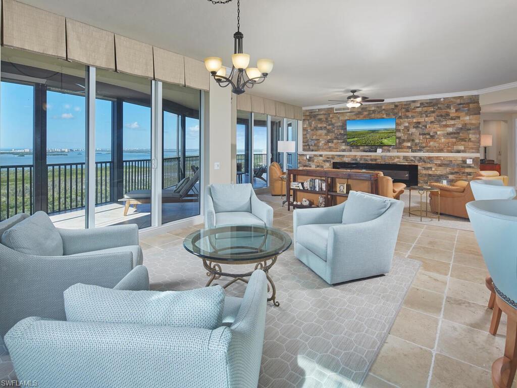 Living room with a chandelier, a water view, and ceiling fan