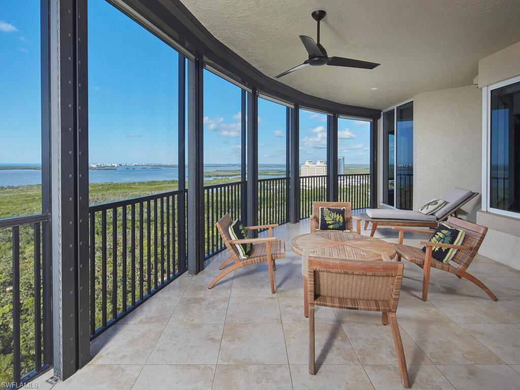 Sunroom featuring floor to ceiling windows, a water view, a textured ceiling, and tile patterned flooring
