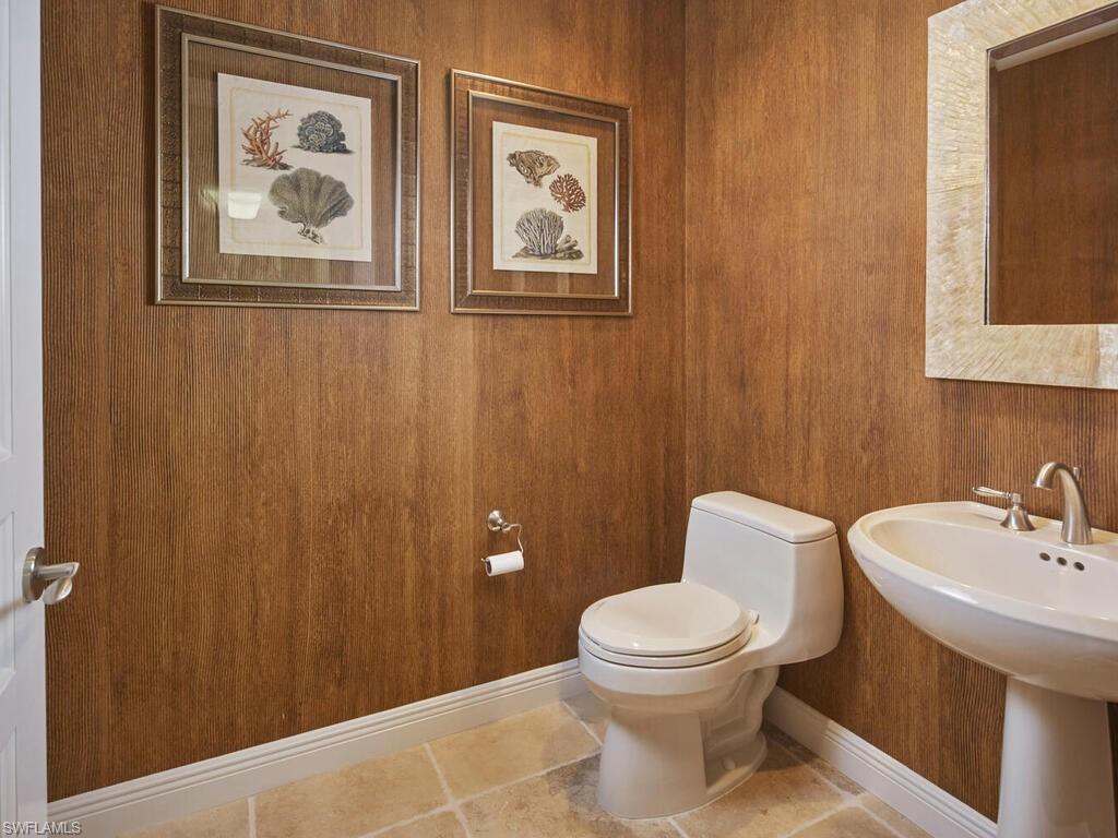Bathroom featuring toilet and wood walls