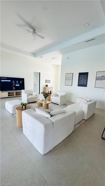 Open-concept room featuring light-toned tile flooring, tray ceiling with recessed lighting, and a ceiling fan
