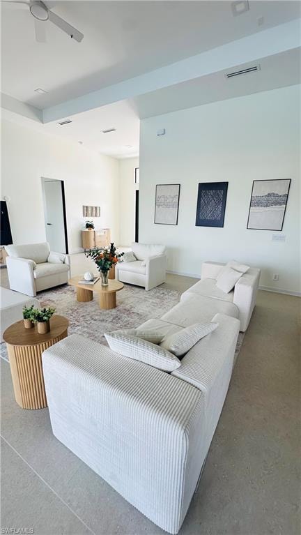 Expansive living area featuring light-toned flooring, high ceilings, and recessed lighting
