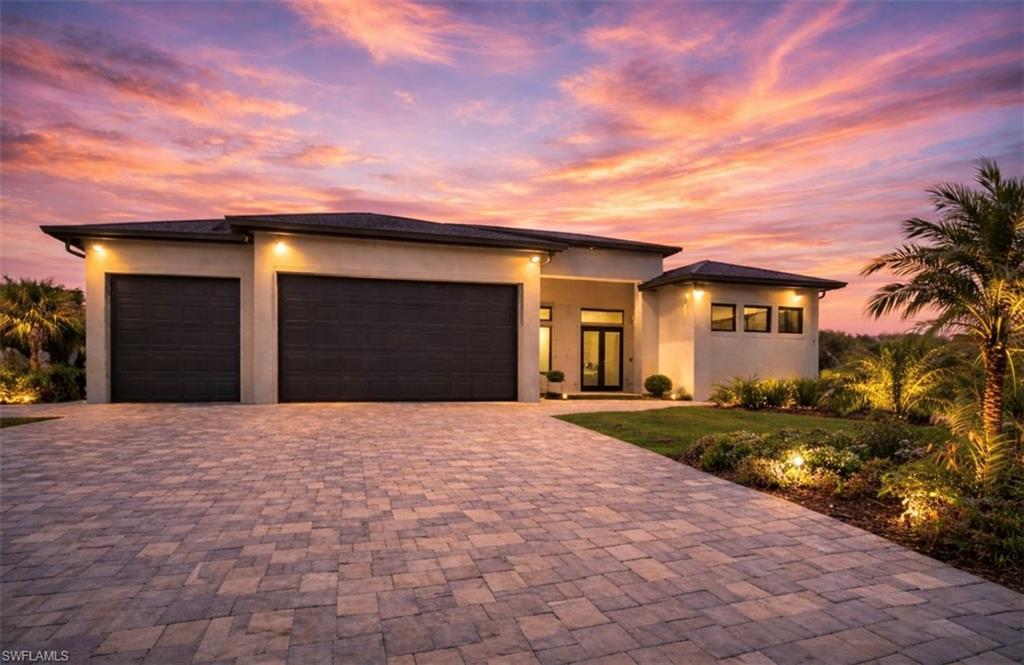 Prairie-style home featuring a garage, stucco siding, and driveway (Rendered photo)