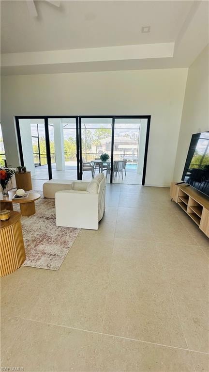Spacious interior featuring neutral tile flooring and soaring ceilings