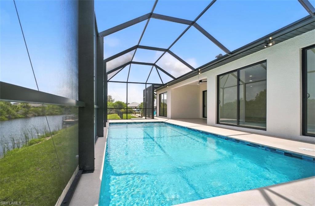 Swimming pool featuring a sunroom, a lanai, and a patio area
