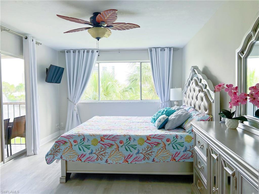Bedroom featuring access to outside, light wood-style floors, and a ceiling fan