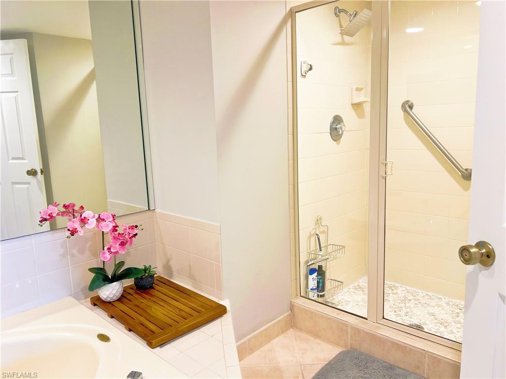 Bathroom with a stall shower and tile patterned floors