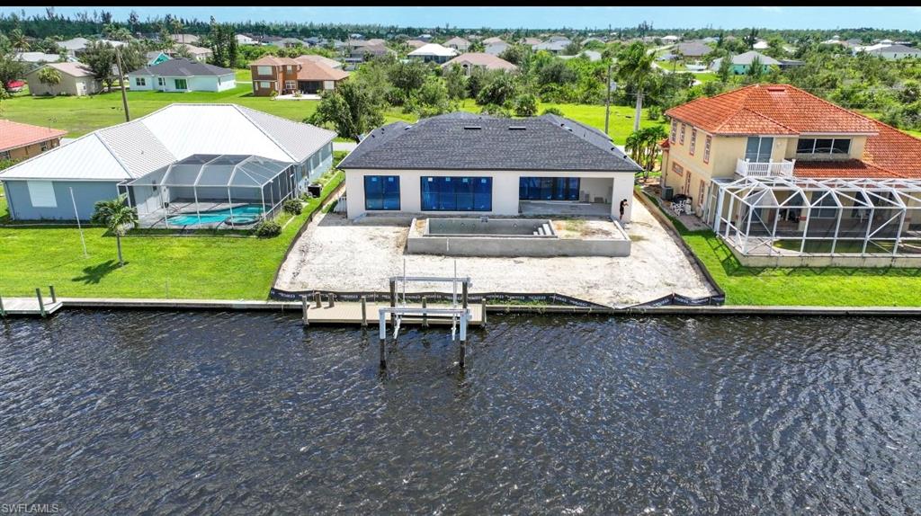 Dock area featuring a sunroom, glass enclosure, boat lift, and a patio area