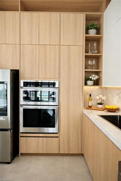 Kitchen with modern cabinets, light wood finish cabinetry, stainless steel appliances, and open shelves