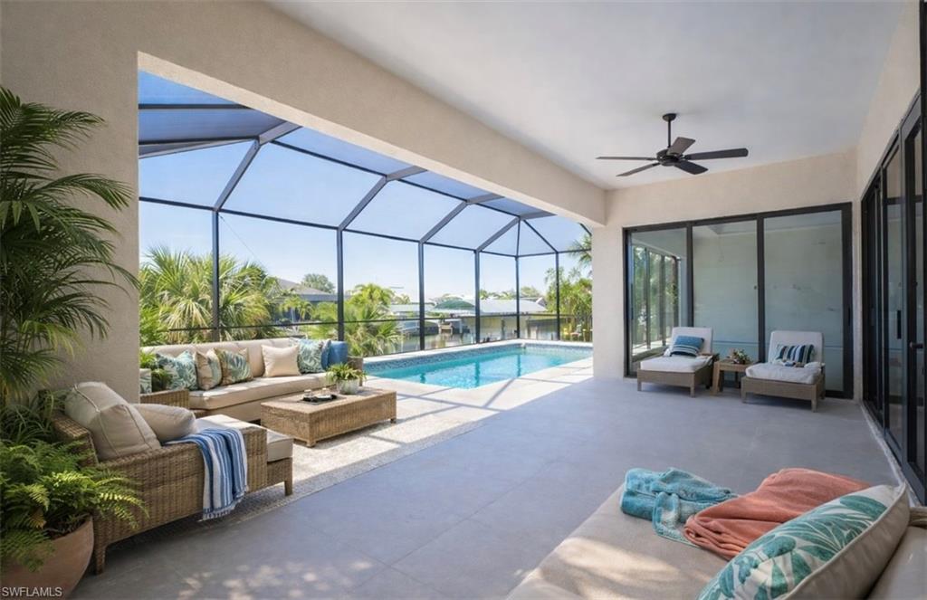 Outdoor pool featuring an outdoor hangout area, a sunroom, glass enclosure, and a patio (Rendered photo)