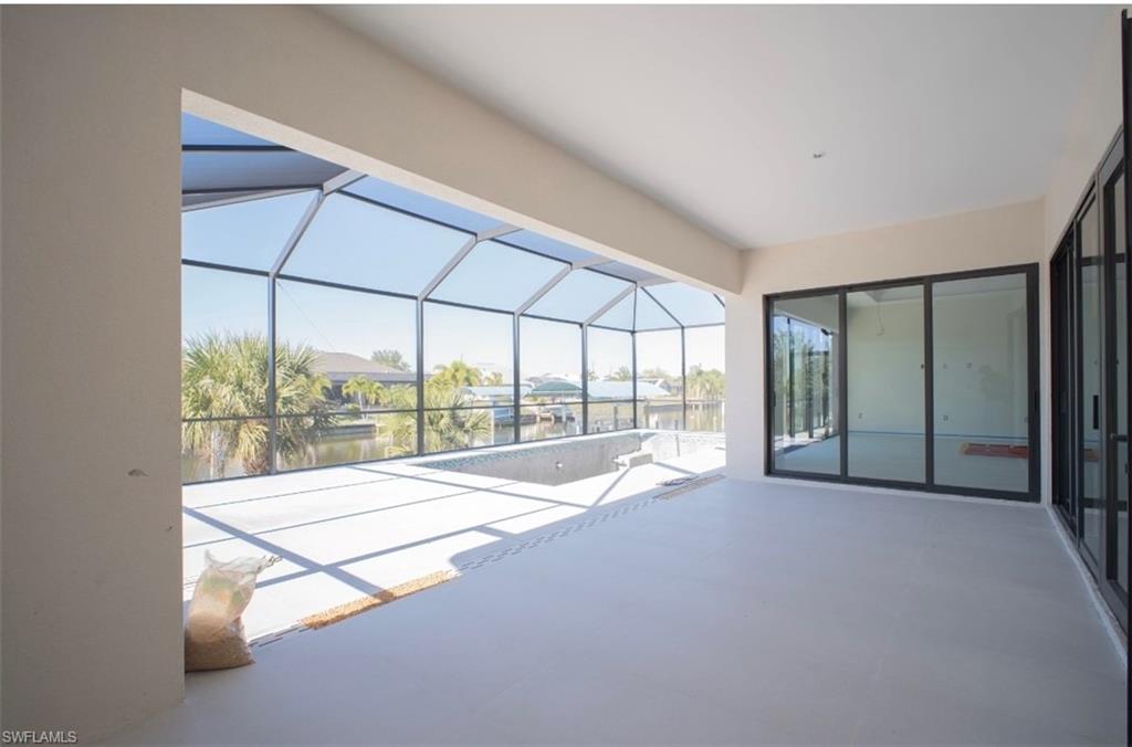View of patio / terrace featuring a lanai, a sunroom, an outdoor pool, and a water view