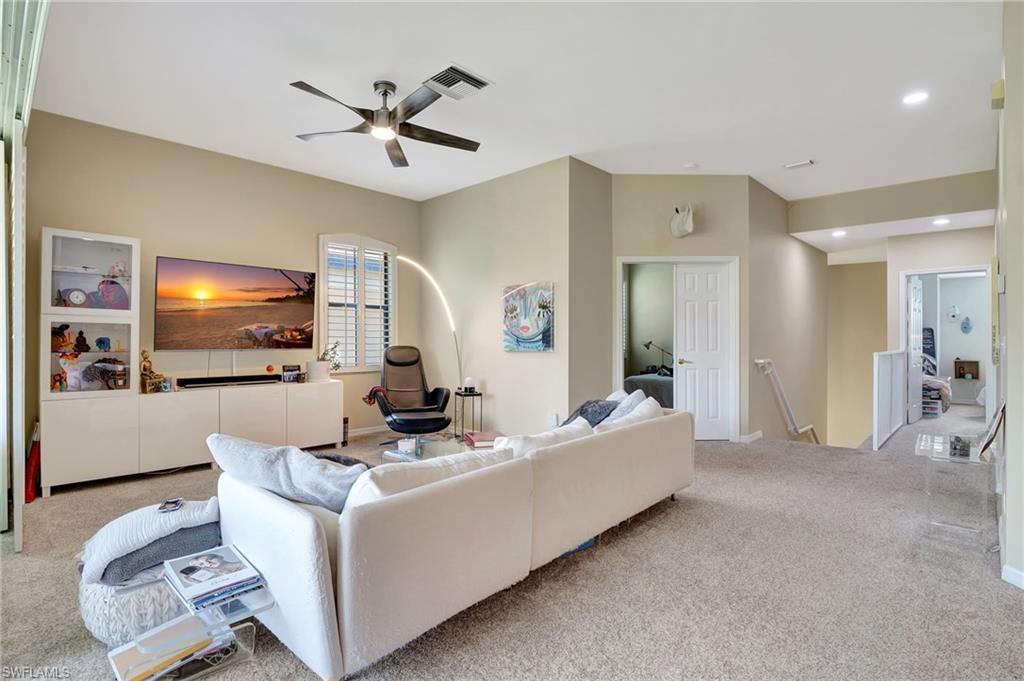 Living area with visible vents, a ceiling fan, carpet floors, and recessed lighting