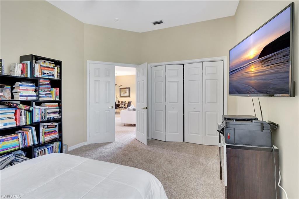 Carpeted bedroom with baseboards, visible vents, and a closet
