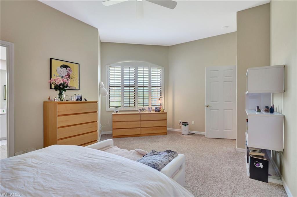 Carpeted bedroom featuring a ceiling fan and baseboards