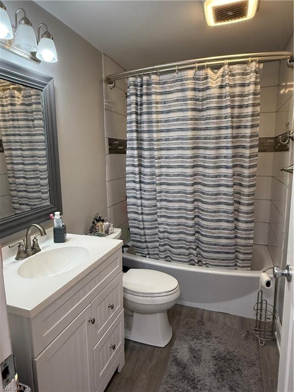 Full bathroom featuring shower / bath combo, dark wood-style flooring, and vanity