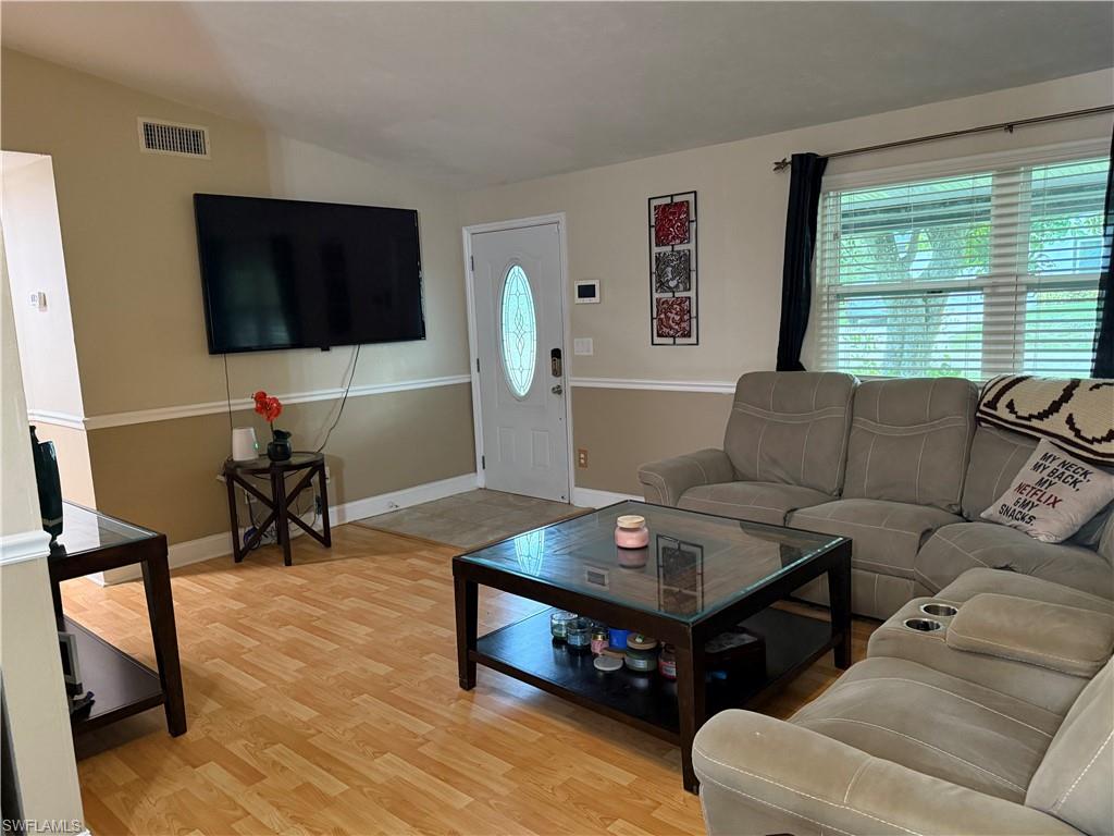 Living area featuring light wood-style flooring and vaulted ceiling