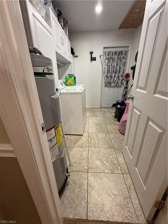 Laundry room featuring independent washer and dryer, water heater, cabinet space, and light tile patterned flooring