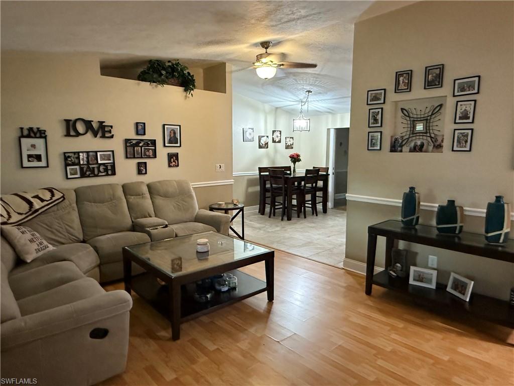 Living area with a ceiling fan, and light wood-style floors